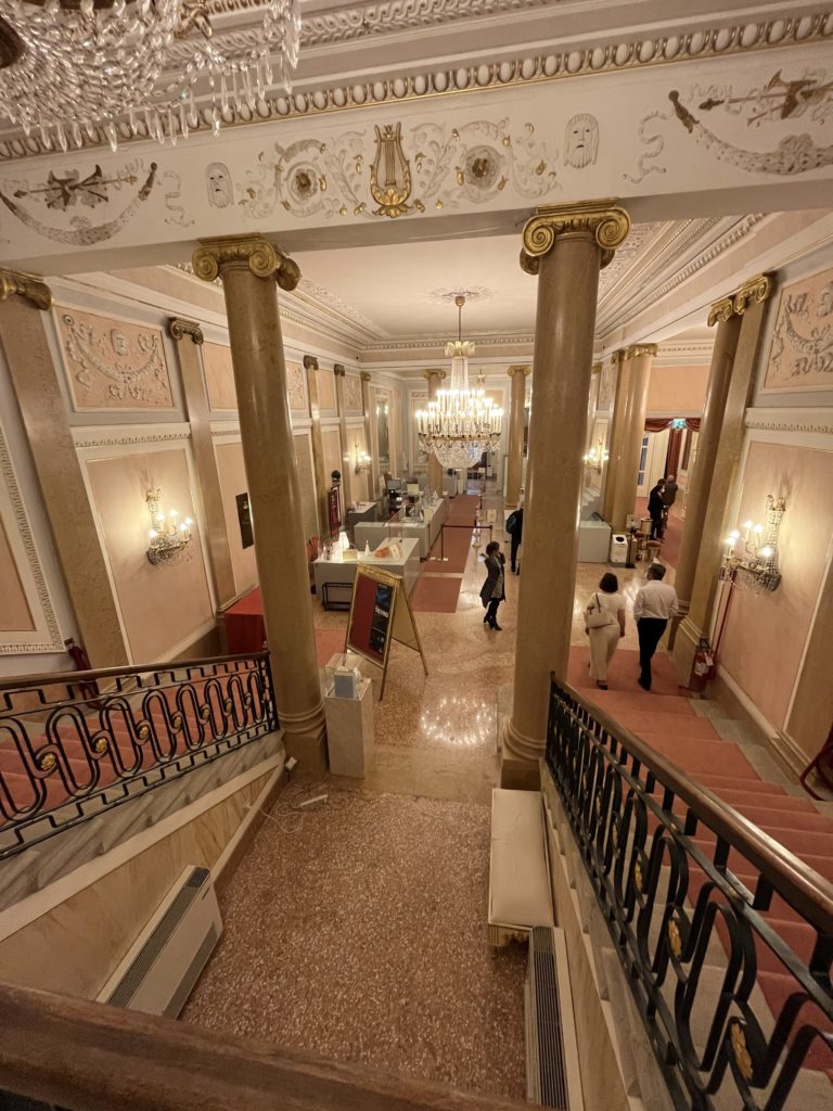 Looking down into the ornate lobby and chandeliers at La Fenice Opera House in Venice